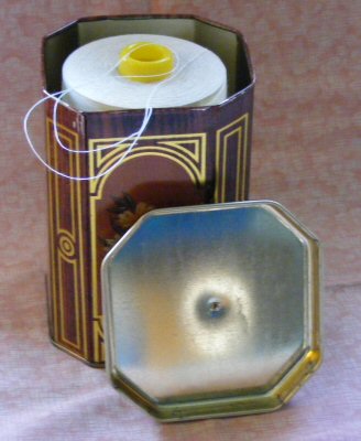 Repurposed Tin that Holds Spool of Thread